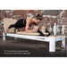 Contour Studio Commercial Pilates Reformer Machine in Beige Colour with Woman Using it while Planking
