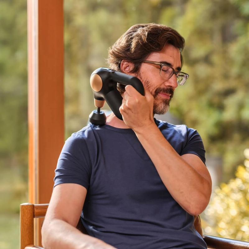 Therabody Theragun Sense 2.0 Massage Gun with male model using it on his traps