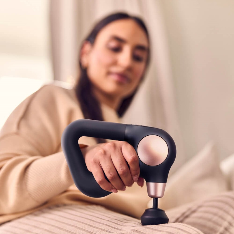 Therabody Theragun Sense 2.0 Massage Gun with female model using it on her thigh